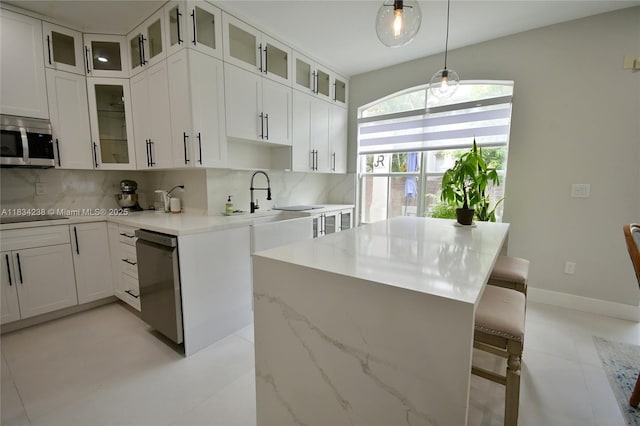 6293 SW 165th Ave, Miami, FL 33193 - kitchen with stainless steel appliances, backsplash, a kitchen breakfast bar, and white cabinets