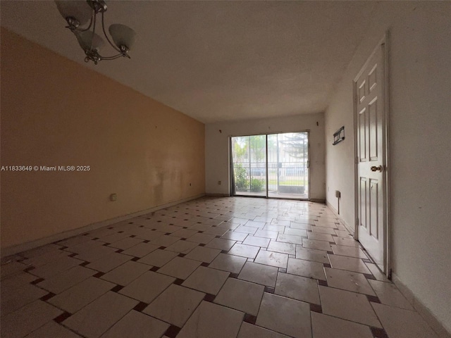 1555 W 44th Pl Unit 103, Hialeah, FL 33012 - spare room with baseboards and a chandelier