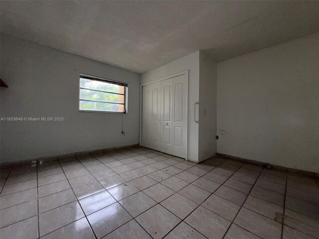 1555 W 44th Pl Unit 103, Hialeah, FL 33012 - unfurnished bedroom with a closet and light tile patterned floors
