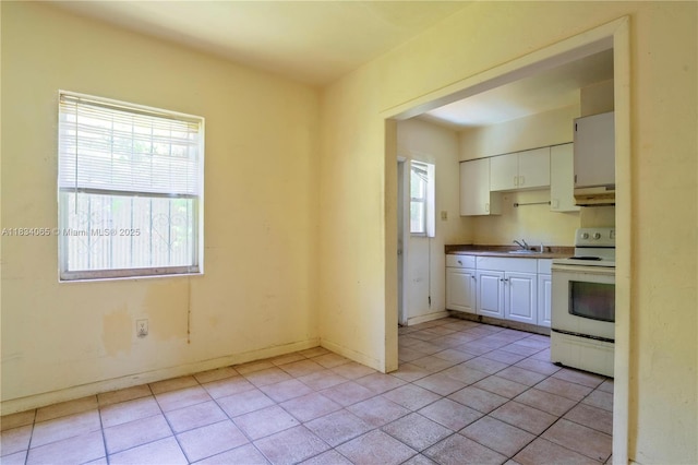 3255 William Ave, Miami, FL 33133 - kitchen with white range with electric cooktop, white cabinetry, light tile patterned floors, and under cabinet range hood