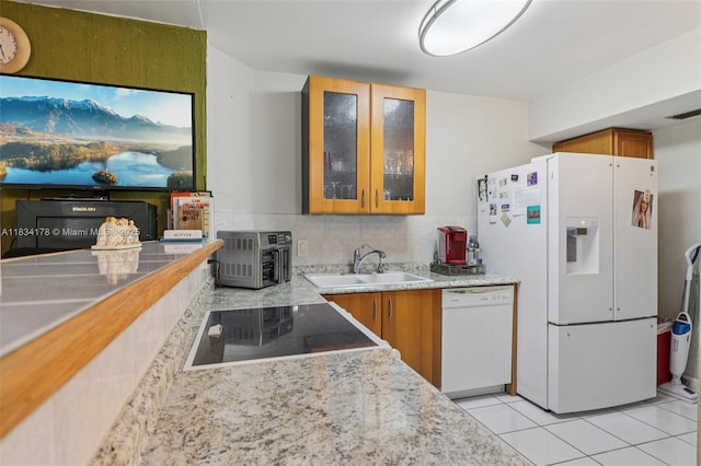 4350 Hillcrest Dr Unit 303, Hollywood, FL 33021 - kitchen featuring white appliances, brown cabinetry, light tile patterned floors, and glass insert cabinets