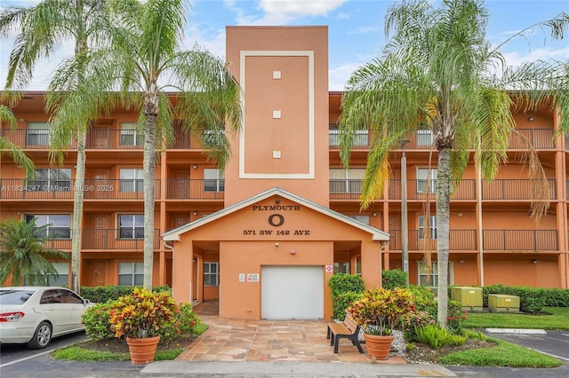 571 SW 142nd Ave Unit 410O, Pembroke Pines, FL 33027 - view of apartment building / complex featuring an attached garage and uncovered parking