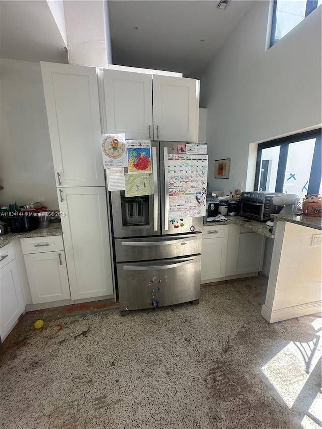 5900 NE 21st Ln, Fort Lauderdale, FL 33308 - kitchen with stainless steel fridge, white cabinetry, and a high ceiling