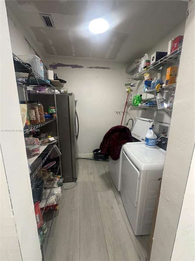 5900 NE 21st Ln, Fort Lauderdale, FL 33308 - washroom featuring washer and clothes dryer and light wood-style floors