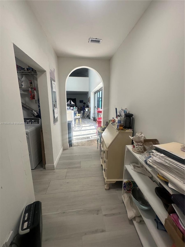 5900 NE 21st Ln, Fort Lauderdale, FL 33308 - hallway with washer / clothes dryer, arched walkways, and light wood-style flooring