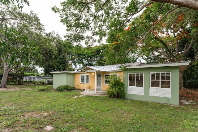 7997 SW 98th Ter, Miami, FL 33156 - ranch-style house with a front yard, a metal roof, stone siding, and stucco siding