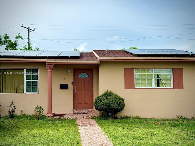 701 NW 176th Ter, Miami Gardens, FL 33169 - view of front of property with a front lawn, stucco siding, and roof mounted solar panels