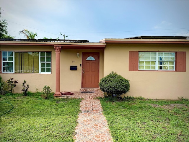 701 NW 176th Ter, Miami Gardens, FL 33169 - property entrance with stucco siding and a lawn