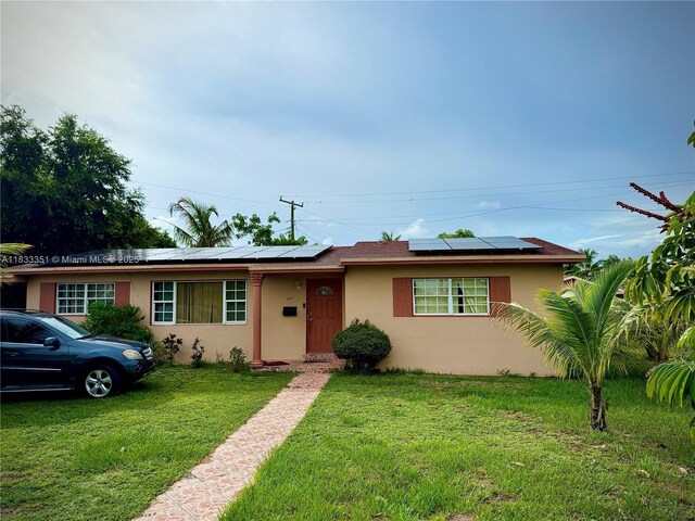 701 NW 176th Ter, Miami Gardens, FL 33169 - view of front of property with stucco siding, solar panels, and a front yard