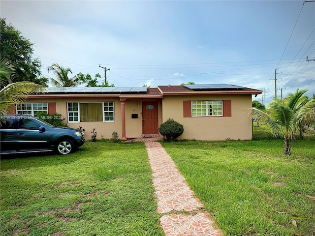 701 NW 176th Ter, Miami Gardens, FL 33169 - view of front of home with stucco siding, roof mounted solar panels, and a front lawn