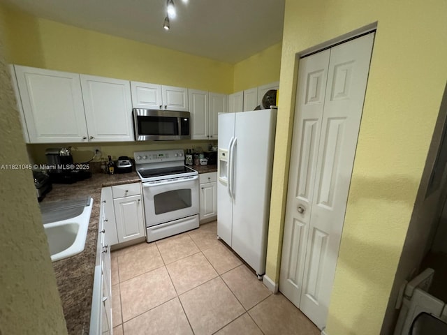 9267 SW 227th St Unit 5-8, Cutler Bay, FL 33190 - kitchen with white appliances, white cabinets, light tile patterned floors, and dark countertops