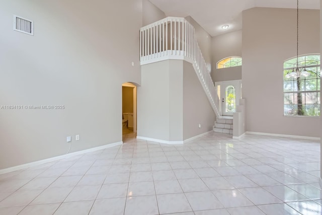12700 SW 18th St, Miramar, FL 33027 - unfurnished living room featuring arched walkways, a towering ceiling, and stairs