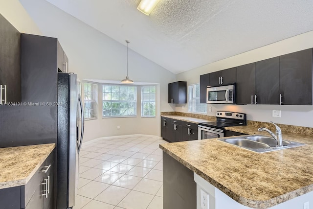 12700 SW 18th St, Miramar, FL 33027 - kitchen featuring stainless steel appliances, vaulted ceiling, dark cabinets, light tile patterned flooring, and pendant lighting