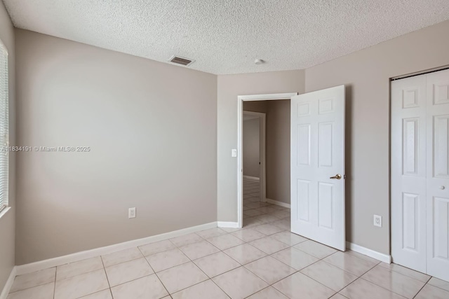 12700 SW 18th St, Miramar, FL 33027 - unfurnished bedroom with a textured ceiling, light tile patterned floors, and a closet