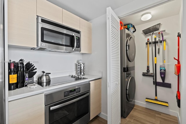 4250 Biscayne Blvd Unit 1218, Miami, FL 33137 - kitchen with stainless steel appliances, estacked washer and dryer, light countertops, light wood finished floors, and modern cabinets