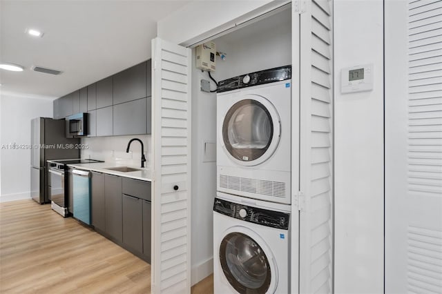 403 SW 12th Ave, Miami, FL 33130 - laundry area with stacked washing machine and dryer and light wood-style floors