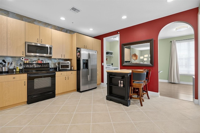 153 Apalachee Ln, Jupiter, FL 33458 - kitchen with stainless steel appliances, dark countertops, light brown cabinets, backsplash, and recessed lighting