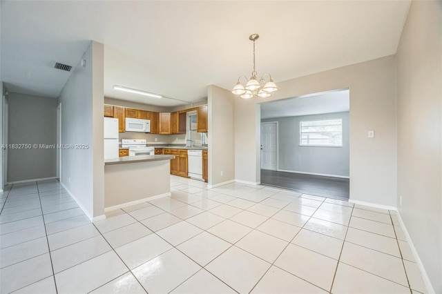 4931 NW 13th St, Lauderhill, FL 33313 - kitchen with white appliances, light tile patterned floors, open floor plan, a chandelier, and decorative light fixtures