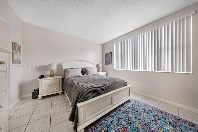 4330 Hillcrest Dr Unit 104, Hollywood, FL 33021 - bedroom featuring light tile patterned floors, a textured ceiling, and vaulted ceiling