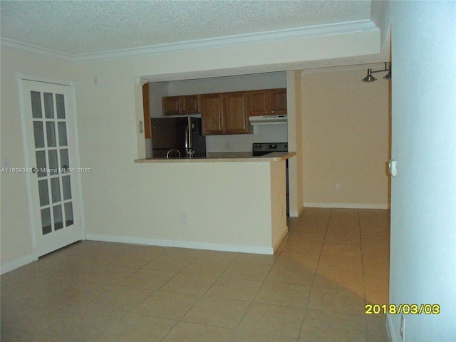 3995 W Mcnab Rd Unit B105, Pompano Beach, FL 33069 - kitchen with freestanding refrigerator, under cabinet range hood, crown molding, a textured ceiling, and range