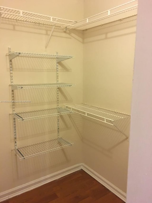 3995 W Mcnab Rd Unit B105, Pompano Beach, FL 33069 - walk in closet with dark wood-style flooring