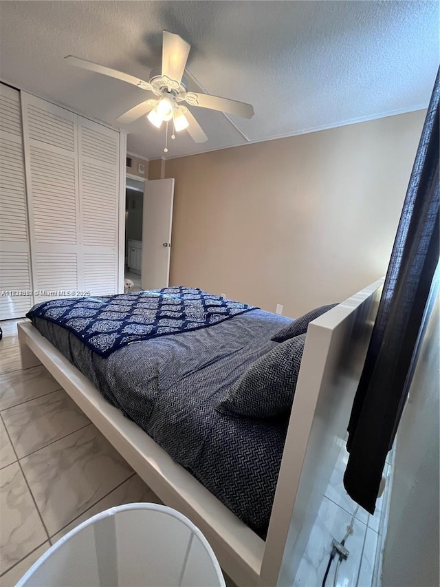 1913 S Ocean Dr Unit 302, Hallandale Beach, FL 33009 - bedroom featuring marble look tile flooring, ceiling fan, a closet, and a textured ceiling