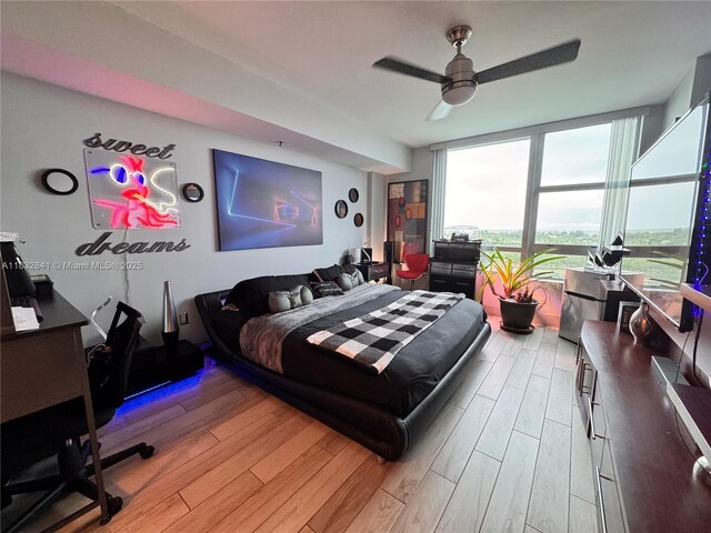 2641 N Flamingo Rd Unit 1203N, Sunrise, FL 33323 - bedroom with expansive windows, light wood-style floors, a desk, and a ceiling fan