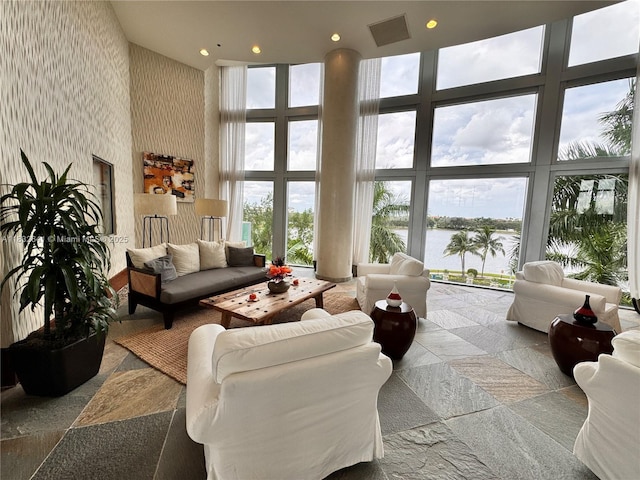 2641 N Flamingo Rd Unit 1203N, Sunrise, FL 33323 - living area with a high ceiling, a water view, a wall of windows, wallpapered walls, and recessed lighting