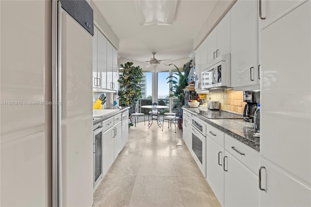 3200 N Ocean Blvd Unit 405, Fort Lauderdale, FL 33308 - kitchen with oven, tasteful backsplash, paneled built in fridge, white cabinets, and black electric cooktop