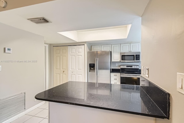 11035 NW 27th St, Sunrise, FL 33322 - kitchen with appliances with stainless steel finishes, light tile patterned floors, dark stone counters, and a peninsula