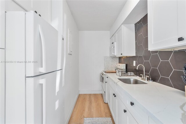 2380 NE 137th St, North Miami Beach, FL 33181 - kitchen featuring white appliances, tasteful backsplash, white cabinetry, light stone countertops, and light wood finished floors