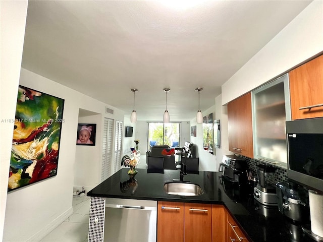 680 NE 64th St Unit A501, Miami, FL 33138 - kitchen featuring stainless steel appliances, a peninsula, brown cabinetry, and dark countertops
