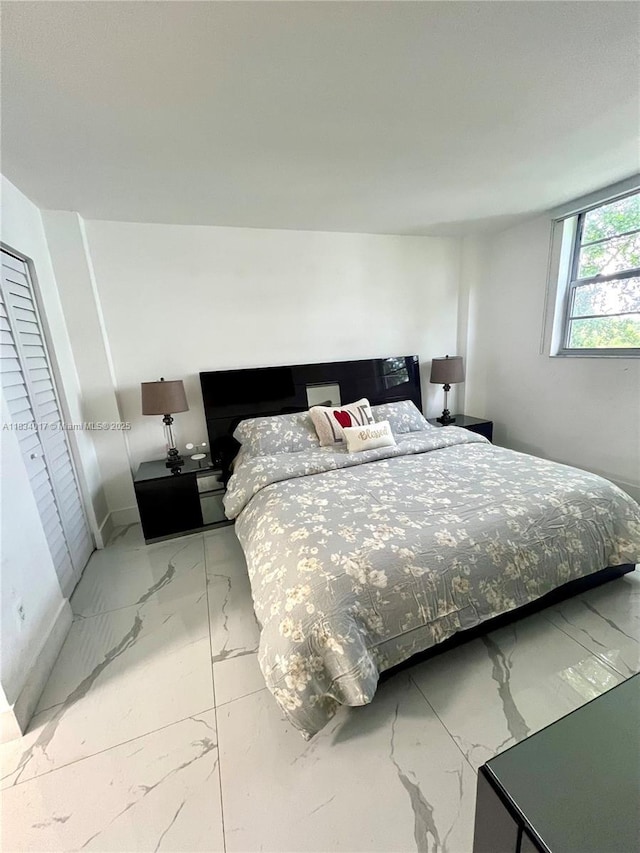 680 NE 64th St Unit A501, Miami, FL 33138 - bedroom featuring light marble finish flooring and baseboards