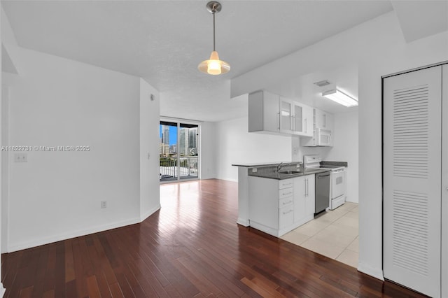 275 NE 18th St Unit 706, Miami, FL 33132 - kitchen featuring white appliances, white cabinets, dark countertops, and light wood finished floors