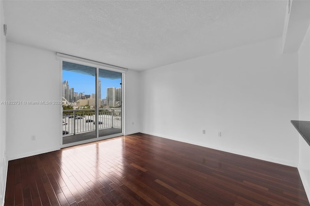 275 NE 18th St Unit 706, Miami, FL 33132 - empty room with hardwood / wood-style floors, a skyline view, a textured ceiling, and floor to ceiling windows