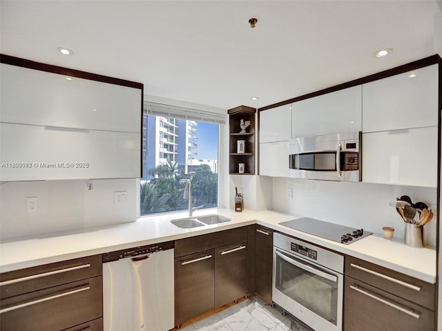 1627 Brickell Ave Unit 605, Miami, FL 33129 - kitchen featuring stainless steel appliances, light marble finish floors, dark brown cabinetry, light countertops, and modern cabinets