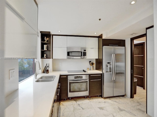 1627 Brickell Ave Unit 605, Miami, FL 33129 - kitchen with appliances with stainless steel finishes, white cabinetry, dark brown cabinets, light countertops, and recessed lighting