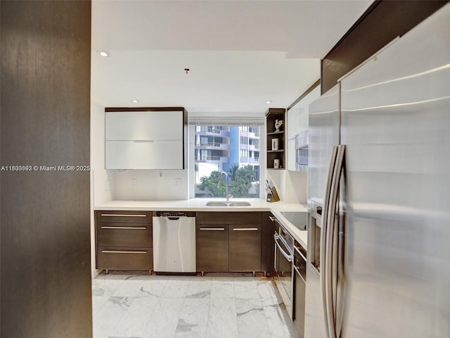 1627 Brickell Ave Unit 605, Miami, FL 33129 - kitchen featuring appliances with stainless steel finishes, light marble finish floors, dark brown cabinetry, light countertops, and modern cabinets