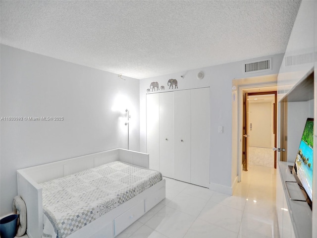 1627 Brickell Ave Unit 605, Miami, FL 33129 - bedroom featuring a textured ceiling, a closet, and light tile patterned flooring