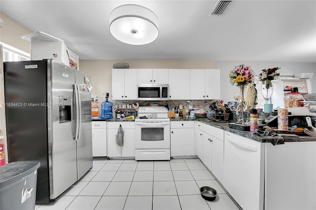1303 W 6th St, Riviera Beach, FL 33404 - kitchen with stainless steel appliances, white cabinets, backsplash, and light tile patterned floors
