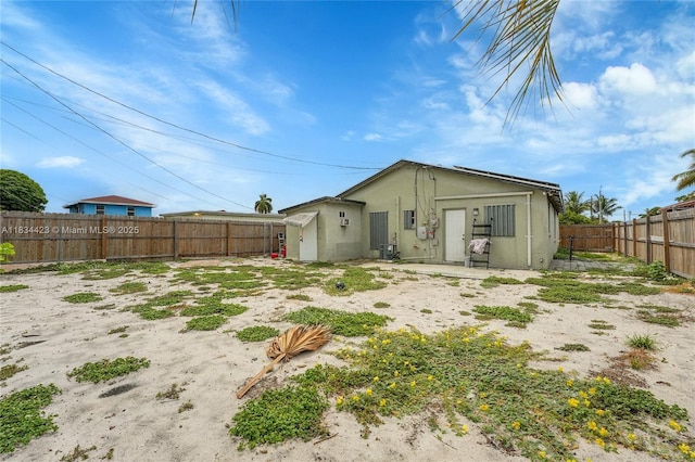 1303 W 6th St, Riviera Beach, FL 33404 - rear view of house with a fenced backyard and stucco siding