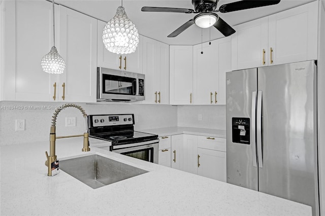 1610 S 29th Ave, Hollywood, FL 33020 - kitchen with appliances with stainless steel finishes, a ceiling fan, white cabinets, and hanging light fixtures