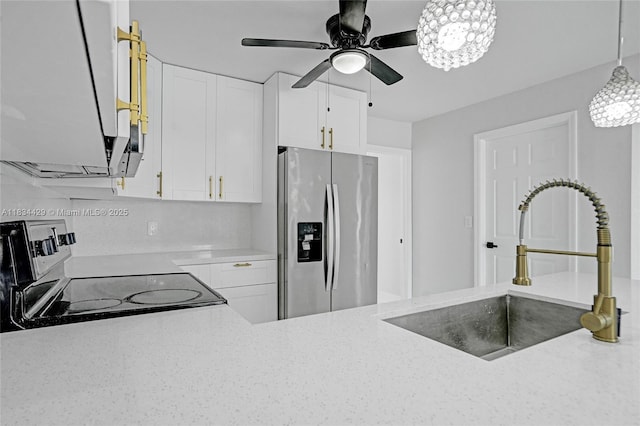 1610 S 29th Ave, Hollywood, FL 33020 - kitchen with stainless steel fridge, range with electric cooktop, a ceiling fan, white cabinetry, and pendant lighting