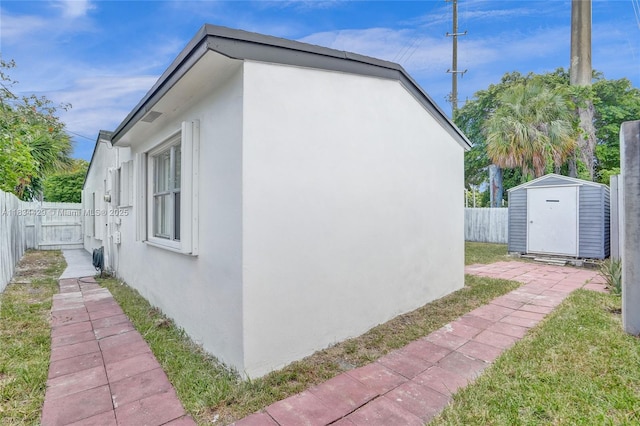 1610 S 29th Ave, Hollywood, FL 33020 - view of side of property with stucco siding, a fenced backyard, and a storage unit