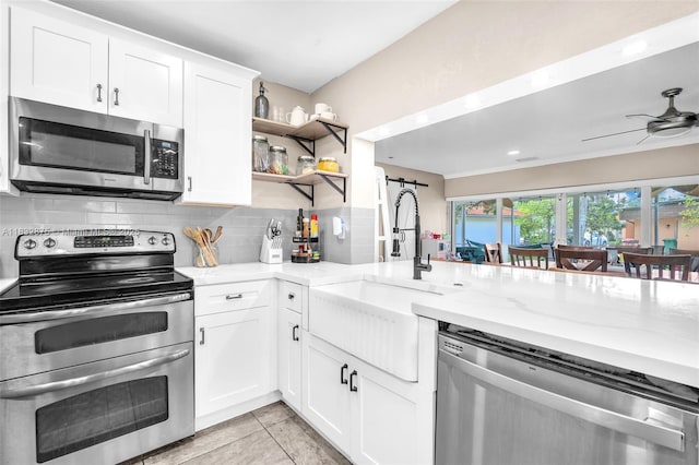 5820 Australian Pine Dr, Tamarac, FL 33319 - kitchen featuring appliances with stainless steel finishes, decorative backsplash, light stone countertops, and white cabinets