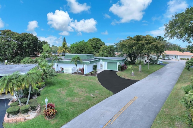 5820 Australian Pine Dr, Tamarac, FL 33319 - view of front of property with a garage, asphalt driveway, and a front lawn