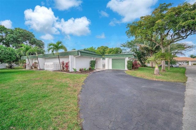 5820 Australian Pine Dr, Tamarac, FL 33319 - view of front of home with asphalt driveway, an attached garage, a front lawn, and stucco siding