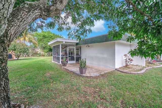 5820 Australian Pine Dr, Tamarac, FL 33319 - rear view of house with stucco siding, a yard, a sunroom, mansard roof, and a patio area