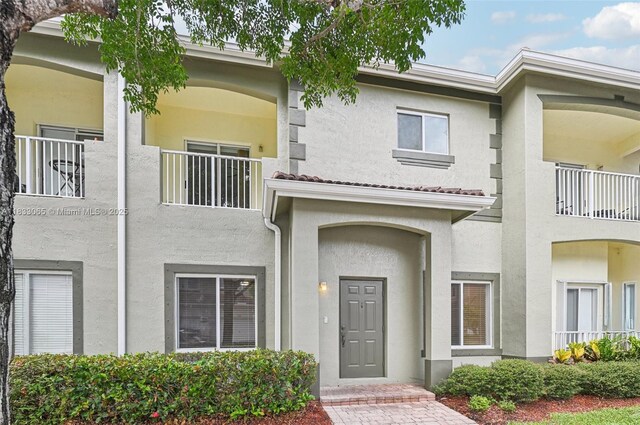 2456 SE 19th Ct, Homestead, FL 33035 - view of front of property with stucco siding and a balcony