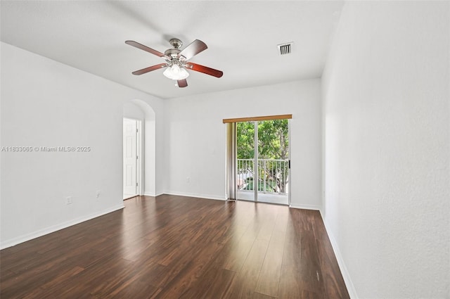 2456 SE 19th Ct, Homestead, FL 33035 - empty room with a ceiling fan, arched walkways, and dark wood-style flooring